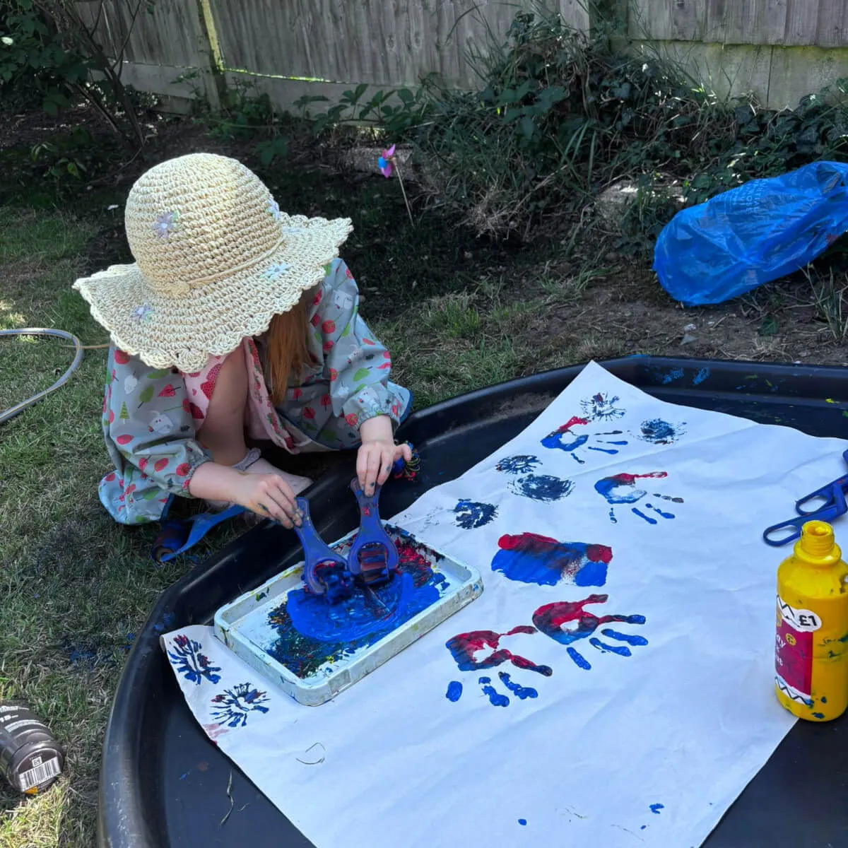 Child hand painting outside
